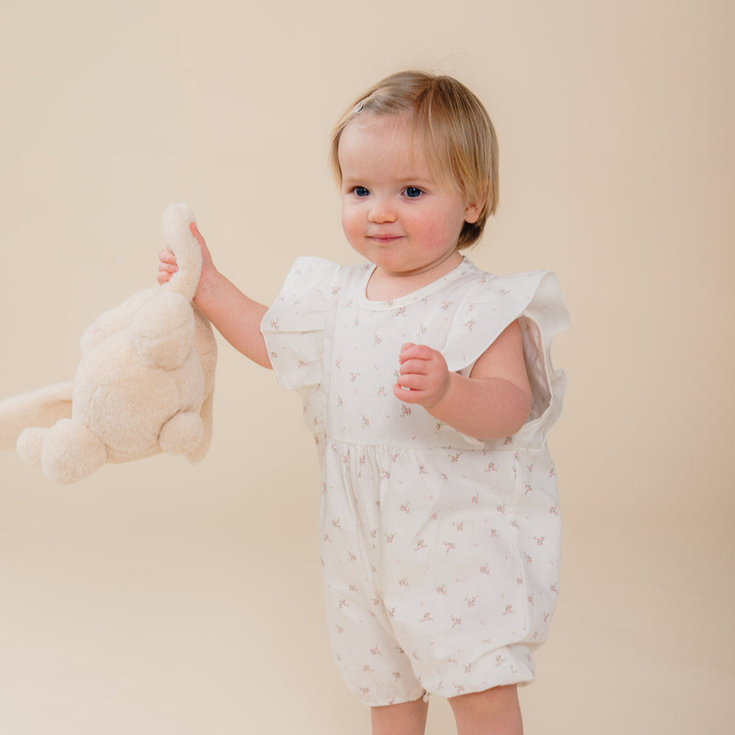 Schattig baby meisje met Atelier Bonheur romper pyjama wit met roze bloemetjes