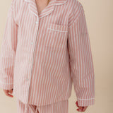 Meisje draagt een roze gestreepte katoenen pyjama uit de Striped Dreams collectie van Atelier Bonheur. Comfortabele en stijlvolle nachtkleding voor kinderen.

