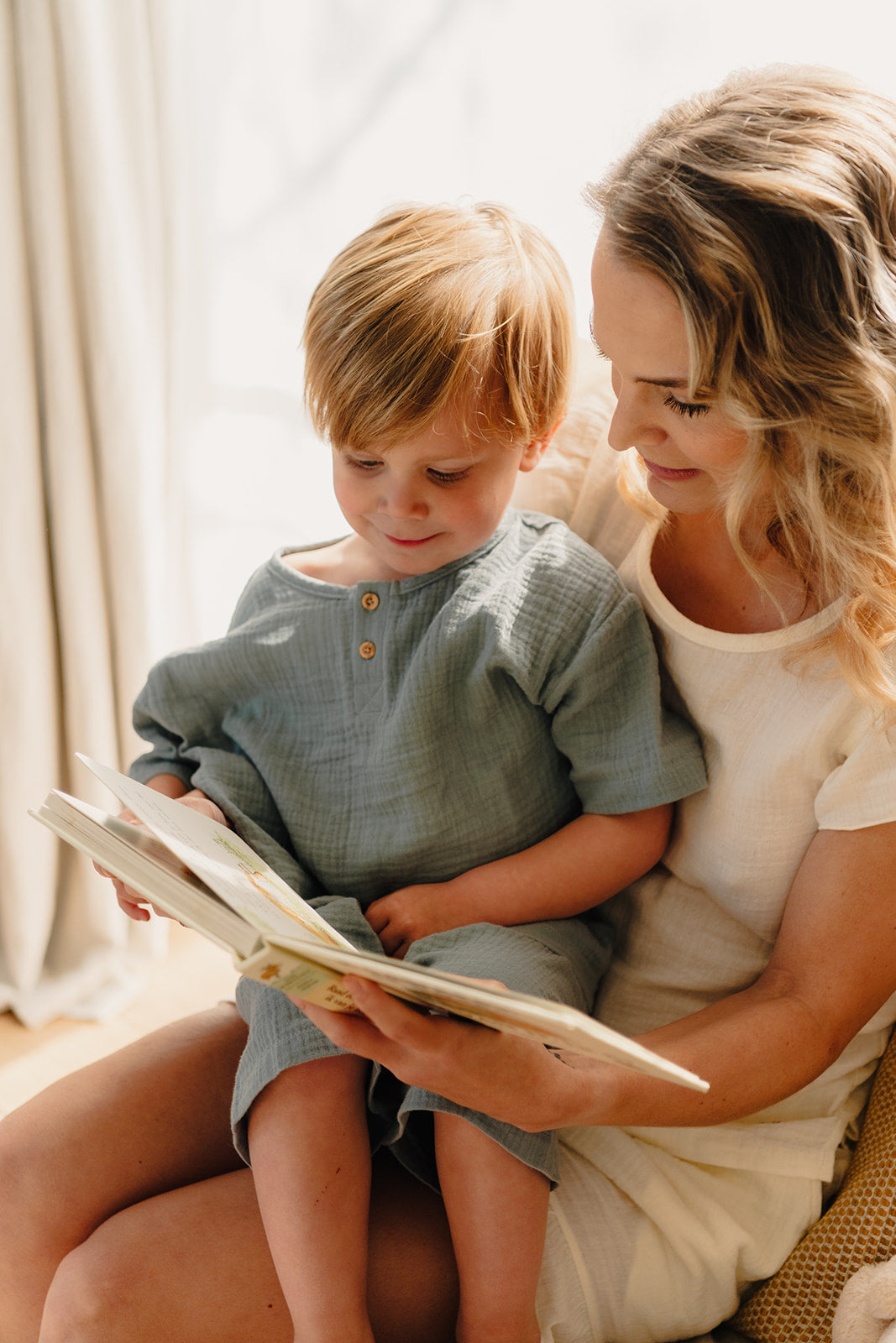 Voorleesmoment mama en zoontje in Atelier Bonheur mousseline pyjama. Zachte pyjama van 100% katoen, assorti voor het hele gezin.